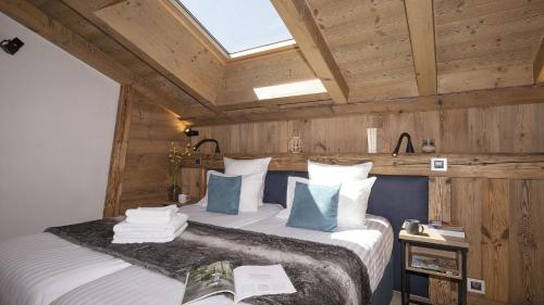 a bedroom with a large bed with a skylight at MGM Hôtels & Résidences - Résidence Alexane in Samoëns