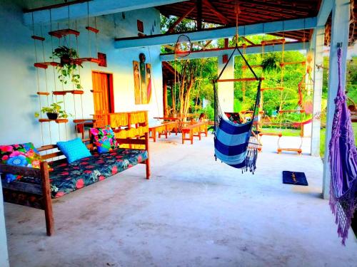 a porch with a swing in a house at Odoyá Corumbau in Corumbau