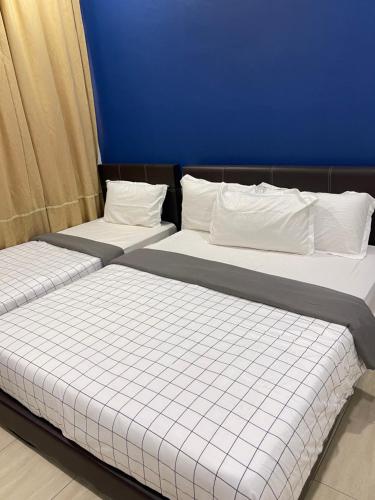 duas camas sentadas uma ao lado da outra num quarto em Coconut House em Malaca