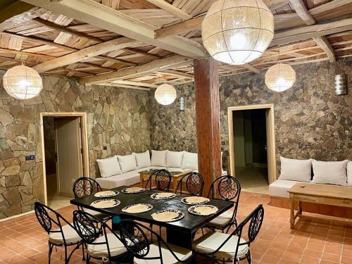 a dining room with a black table and chairs at Chateau Imilchil in Imilchil