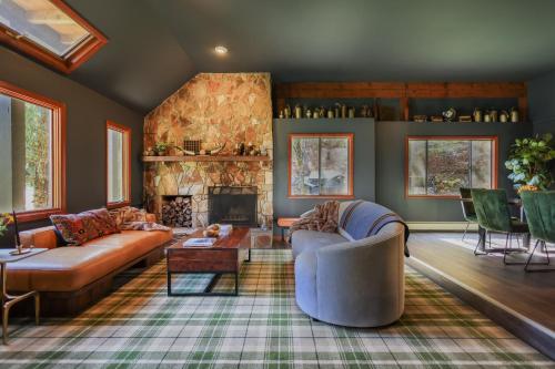 sala de estar con sofá y chimenea en Outland Chalet & Suites Great Smoky Mountains en Whittier