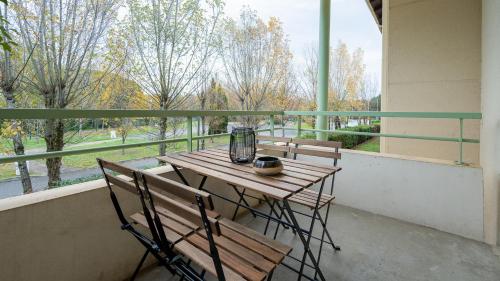 - Balcón con mesa de madera y 2 sillas en Le Pastel - Métro/ Centres de formation-Fac-Thalès en Toulouse