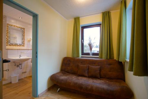 a brown leather couch in a bathroom with a window at Hotel Waldmann in Schwangau