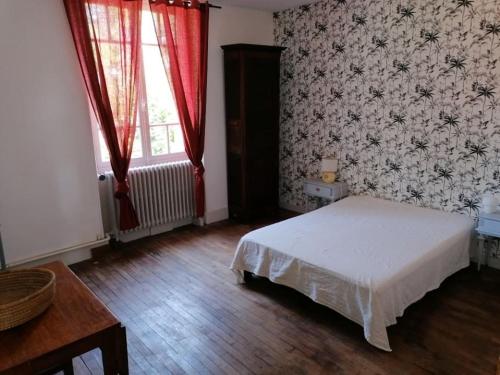 sypialnia z białym łóżkiem i czerwoną zasłoną w obiekcie Appartement indépendant dans grande maison w mieście Pouilly-sur-Loire