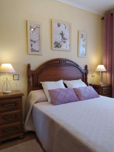 a bedroom with a bed with two lamps and two tables at LA GRANDA DE LA CONCHA in Nueva de Llanes