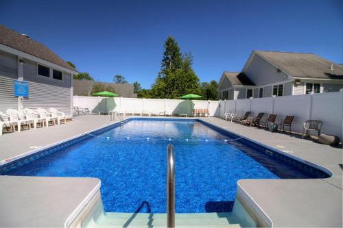 uma piscina com água azul numa casa em Killington Center Inn & Suites by Killington VR - 1 Bedrooms em Killington