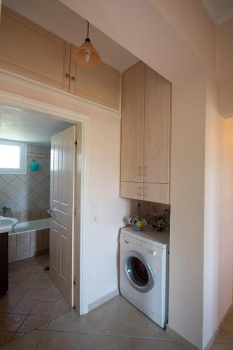 a kitchen with a washing machine in a room at Eleonora's Apartment in Lygia