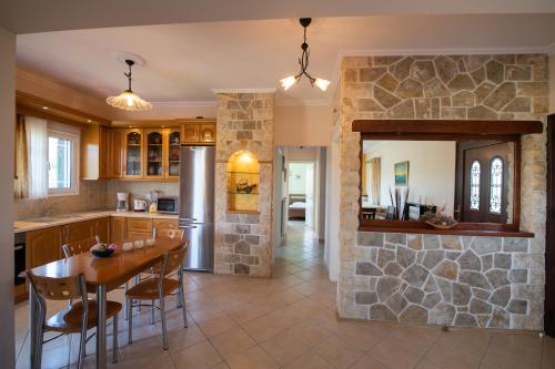 una cucina con tavolo e parete in pietra di Eleonora's Apartment a Lygia