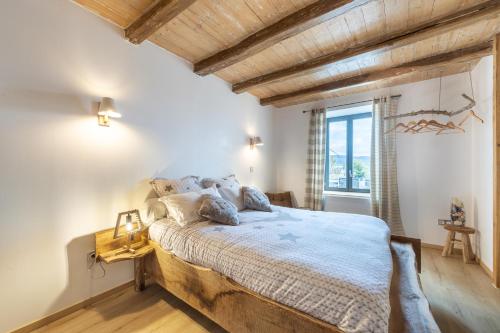 ein Schlafzimmer mit einem großen Bett und einer Holzdecke in der Unterkunft Terre d'Emeraude - Charmante maison avec sauna 