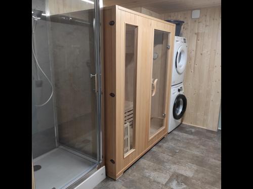 eine Waschküche mit Waschmaschine und Waschmaschine in der Unterkunft Terre d'Emeraude - Charmante maison avec sauna 