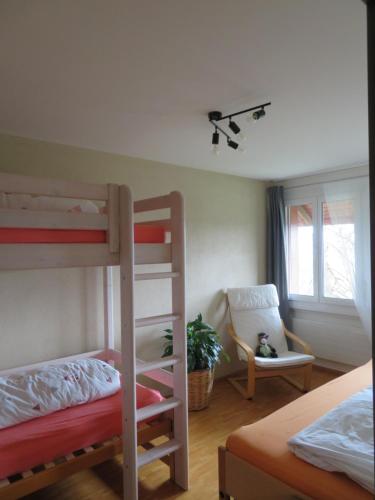 a bedroom with two bunk beds and a chair at Ferienwohnung Frostenegg 