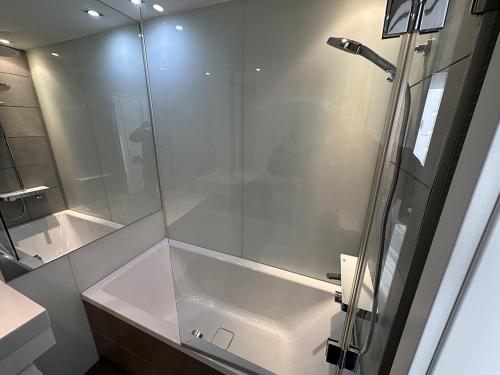 y baño con ducha acristalada y lavamanos. en SKAU Eurovea Duplex Apartment Danube Exclusive View Free Parking, en Bratislava
