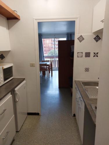 une cuisine avec une porte menant à une salle à manger dans l'établissement Studio SuperDévoluy dans batiment Bois D'Aurouze au pied des pistes, à Saint-Étienne-en-Dévoluy