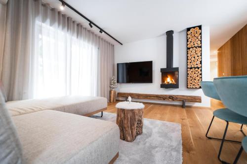 een woonkamer met een bank en een open haard bij Bor in Bor Luxury Apartment with sauna & garden - Kranjska Gora in Kranjska Gora