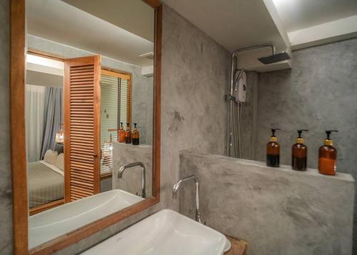 a bathroom with a tub and a sink and a mirror at The Parlour Krabi in Klong Muang Beach