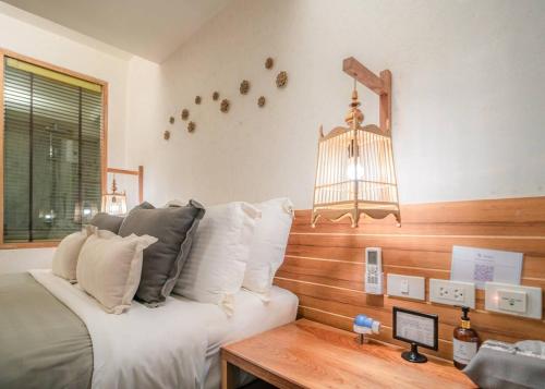 a bedroom with a bed and a desk and a bird cage at The Parlour Krabi in Klong Muang Beach
