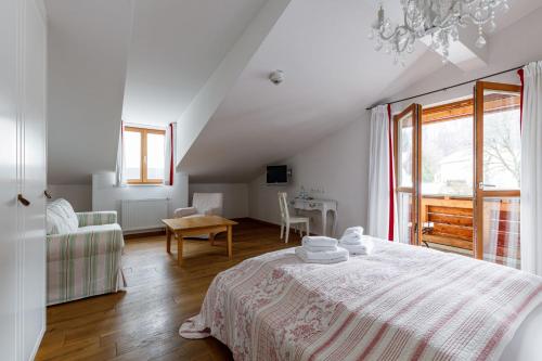 a white bedroom with a bed and a table at Seebacher Haus in Oberaudorf