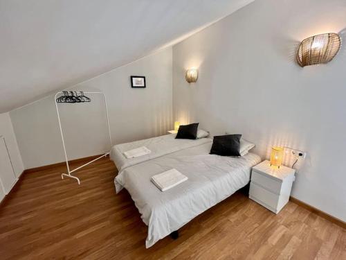 um quarto com 2 camas e lençóis brancos em Apartamento espacioso y familiar em Terrassa