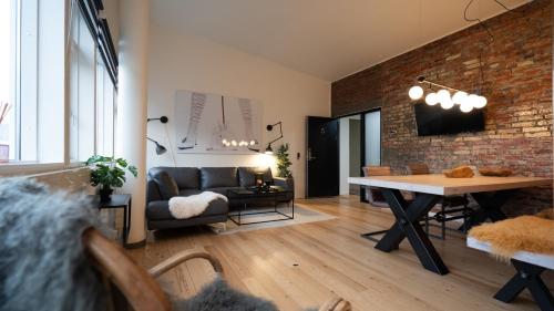 a living room with a table and a brick wall at Broncks Apartment 5 in Tórshavn