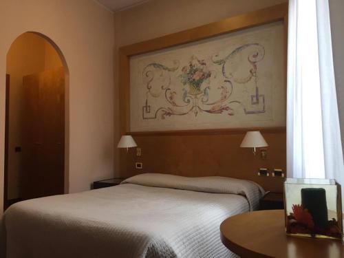 a bedroom with a bed and a painting on the wall at Residence La Fenice in Padova