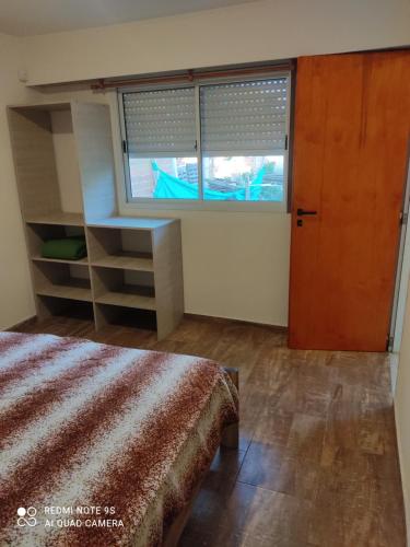 1 dormitorio con cama y ventana grande en depto itagua en 