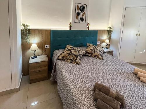 a bedroom with a large bed with a blue headboard at DREAMY SUNSET, SeaFront, Direct Access To The Promenade,Wifi,Free Parking in Los Cristianos