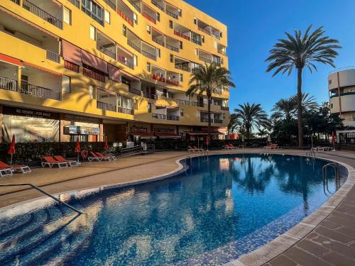 a swimming pool in front of a building at DREAMY SUNSET, SeaFront, Direct Access To The Promenade,Wifi,Free Parking in Los Cristianos