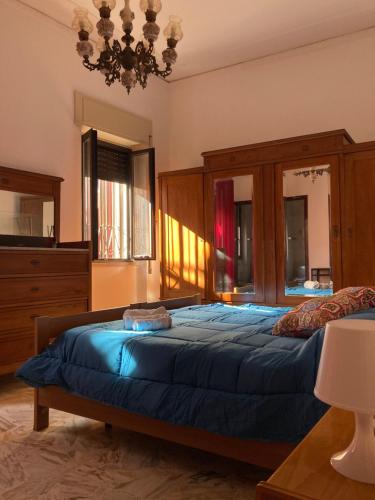 Un dormitorio con una cama grande y una lámpara de araña. en Va' Nedda, en Lentini