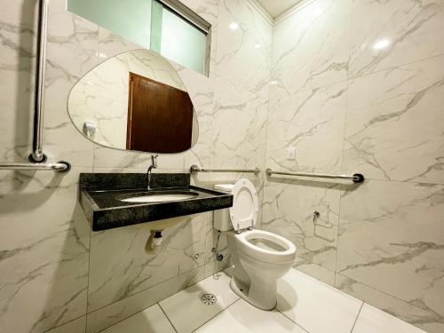a bathroom with a toilet and a sink and a mirror at Pousada Marítimos in Maragogi