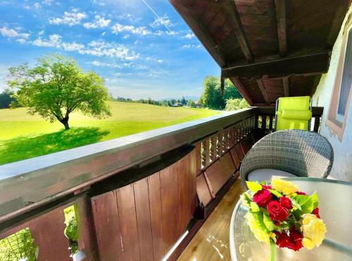 einen Tisch und Stühle auf einem Balkon mit Aussicht in der Unterkunft Ferienwohnung Gruberhof in Rimsting