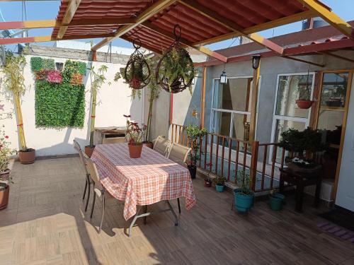eine Terrasse mit einem Tisch und einigen Topfpflanzen in der Unterkunft PentHouse con Roof Garden Privado Aeropuerto CDMX in Mexiko-Stadt