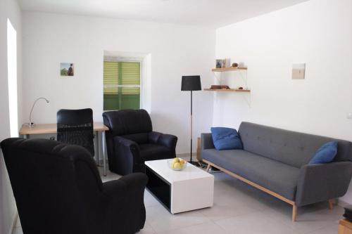 uma sala de estar com duas cadeiras, um sofá e uma mesa em Casa Pé di Polon holiday home em Picos
