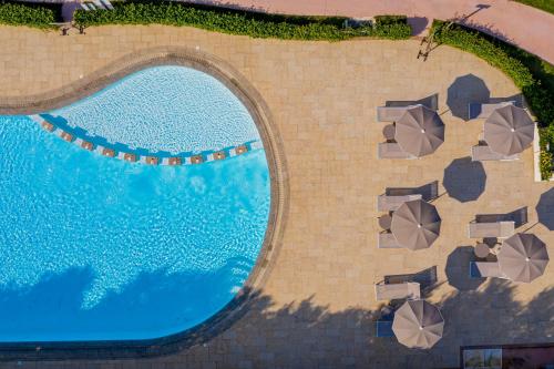 een uitzicht over een zwembad met parasols bij Ville d'Ogliastra 2 - Marina Suites in Cardedu