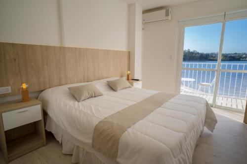 1 dormitorio con cama grande y ventana grande en Santa Cecilia Boutique en Villa Carlos Paz