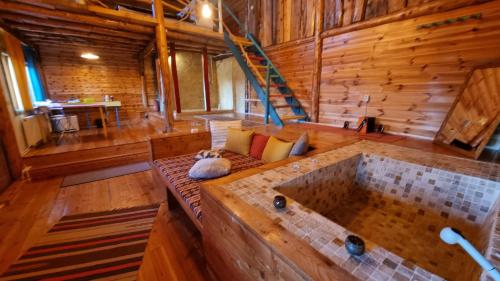 a large room with a tub in a log cabin at Harmonie Tree house Cotagges Chalet Predeal Trei Brazi in Predeal