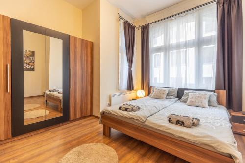 een slaapkamer met een bed en een groot raam bij Wiky's Apartman with 3bathrooms in Boedapest