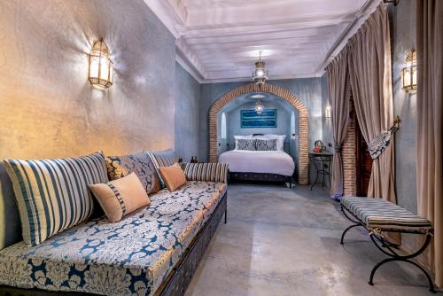 een woonkamer met een bank en een bed bij Maïpa Boutique Riad in Marrakesh
