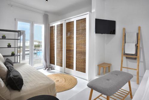 a living room with a couch and a tv at Tohu Villas Mykonos in Ornos