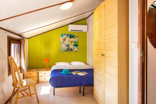 ポルティラーニュにあるLes Tamaris et Les Portes du Soleilのベッドルーム1室(ベッド1台、デスク、椅子付)