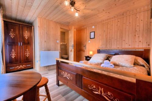 sypialnia z dużym łóżkiem i drewnianą ścianą w obiekcie Dom Wypoczynkowy U Kubusia w mieście Białka Tatrzanska