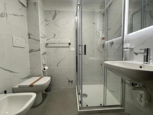 uma casa de banho com um chuveiro, um WC e um lavatório. em Hotel Convertini em Milão