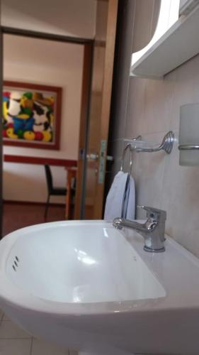 y baño con lavabo blanco y espejo. en Depto en el Centro de Córdoba en Córdoba