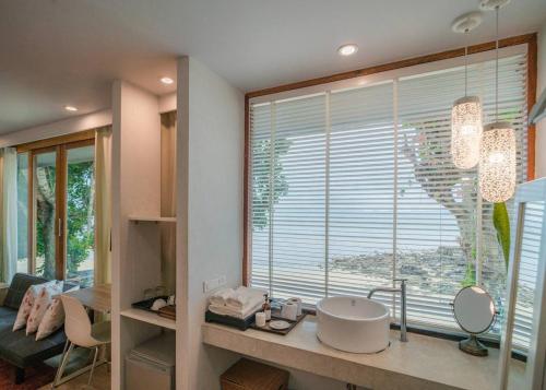 a bathroom with a sink and a large window at The Parlour Krabi in Klong Muang Beach