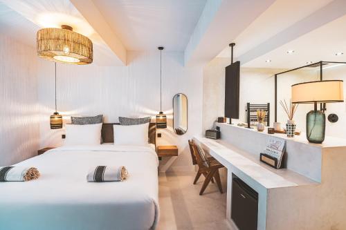 une chambre d'hôtel avec deux lits et un bureau dans l'établissement La Suite des Bouchonniers, à Saint-Tropez