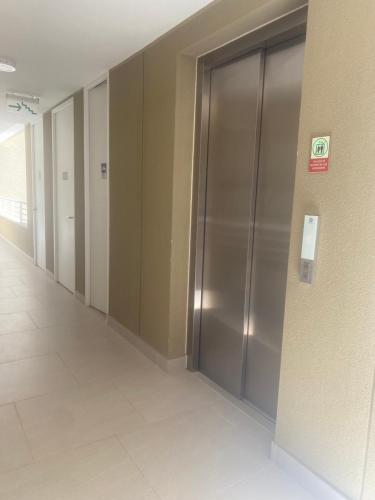 un pasillo vacío con puertas de ascensor en un edificio en Departamento full equipado - con laguna artificial lo mejor del litoral, en Las Cruces