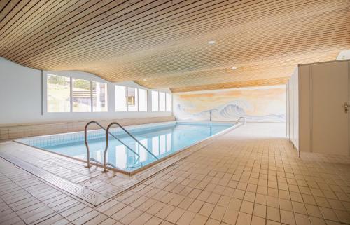 a swimming pool in a building with a mural at Rehwiesa Studio C04 in Arosa