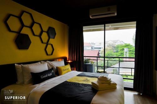 - une chambre avec un grand lit et un balcon dans l'établissement The Hive Chiang Mai Hotel, à Chiang Mai