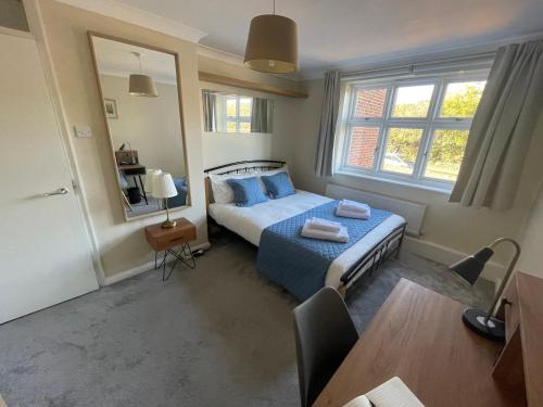 a bedroom with a bed with blue pillows and a table at Apartment with King Bed & Free Parking in London in Southall