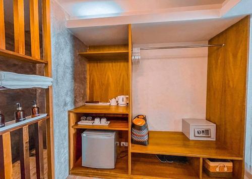 a small kitchen with wooden shelves and a small appliance at The Parlour Krabi in Klong Muang Beach