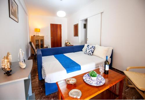 Blue Apartment 2nd floor feel like home properties في Saronida: غرفة نوم بسرير ازرق وبيض وطاولة
